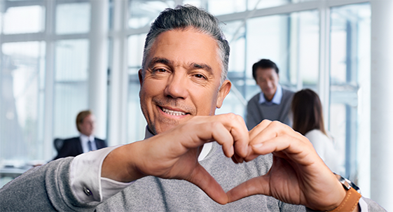 Man smiling and making heart shape with hands