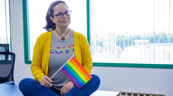 Theresa holding a Pride flag.