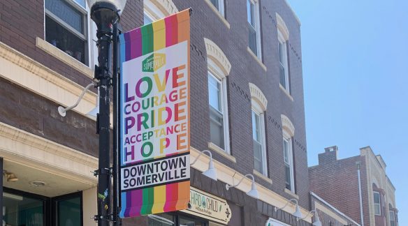 Pride banner hanging on a lamp post in downtown Somerville.
