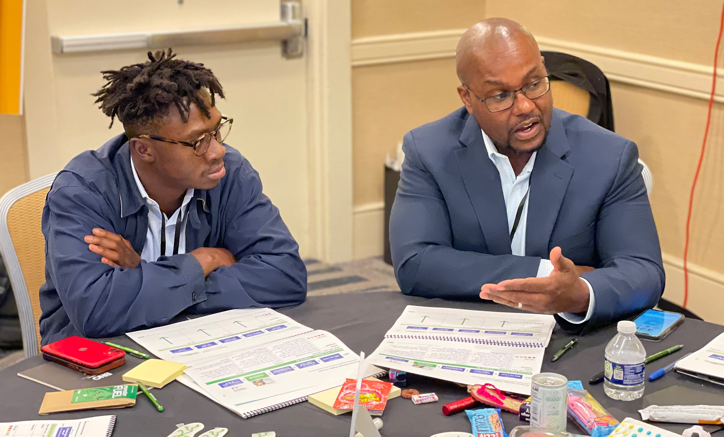 Two workshop attendees discussing their persona with the rest of their team.