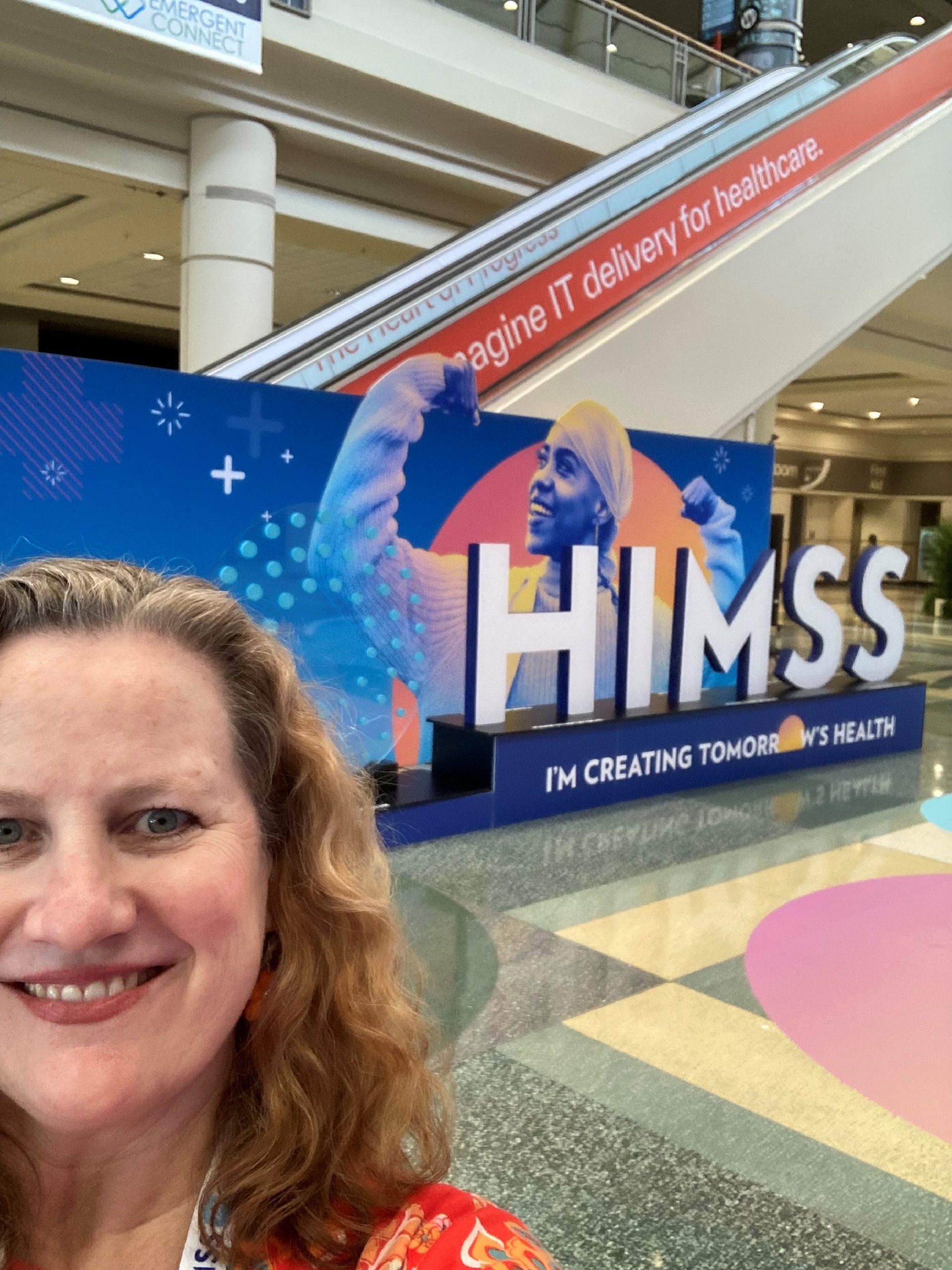 Sheri taking a selfie by the HIMSS sign.