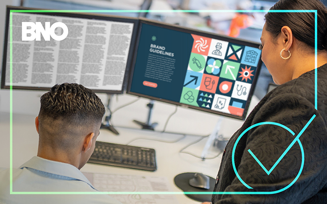Two people looking at brand guidelines in copy.
